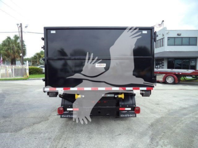 Rear view of a 2019 Hino 195 rolloff truck showing the cargo bed and bumper area with license/stock decals.