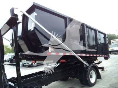 Hino roll-off truck body with hydraulic arm and dump bed in black; visible wheels and side panels with reflective striping.