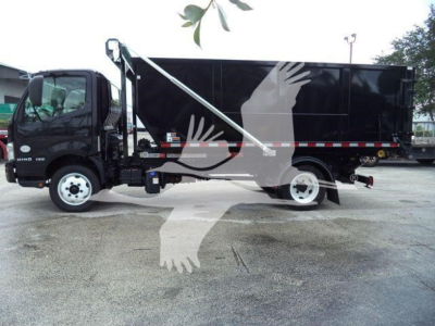 Truck side view showing a black Hino roll-off body with white cab and hydraulic boom, side steps, and roll-off container.