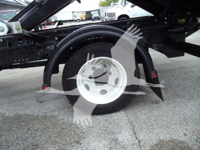 Truck wheel and suspension components of a 2019 Hino 195 roll-off truck showing a single rear wheel and fender with chassis framing.