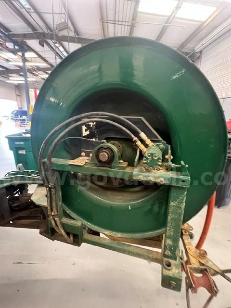 Industrial HVAC-style blower wheel with green housing and mounted control lines; appears as a large industrial fan/air mover assembly.