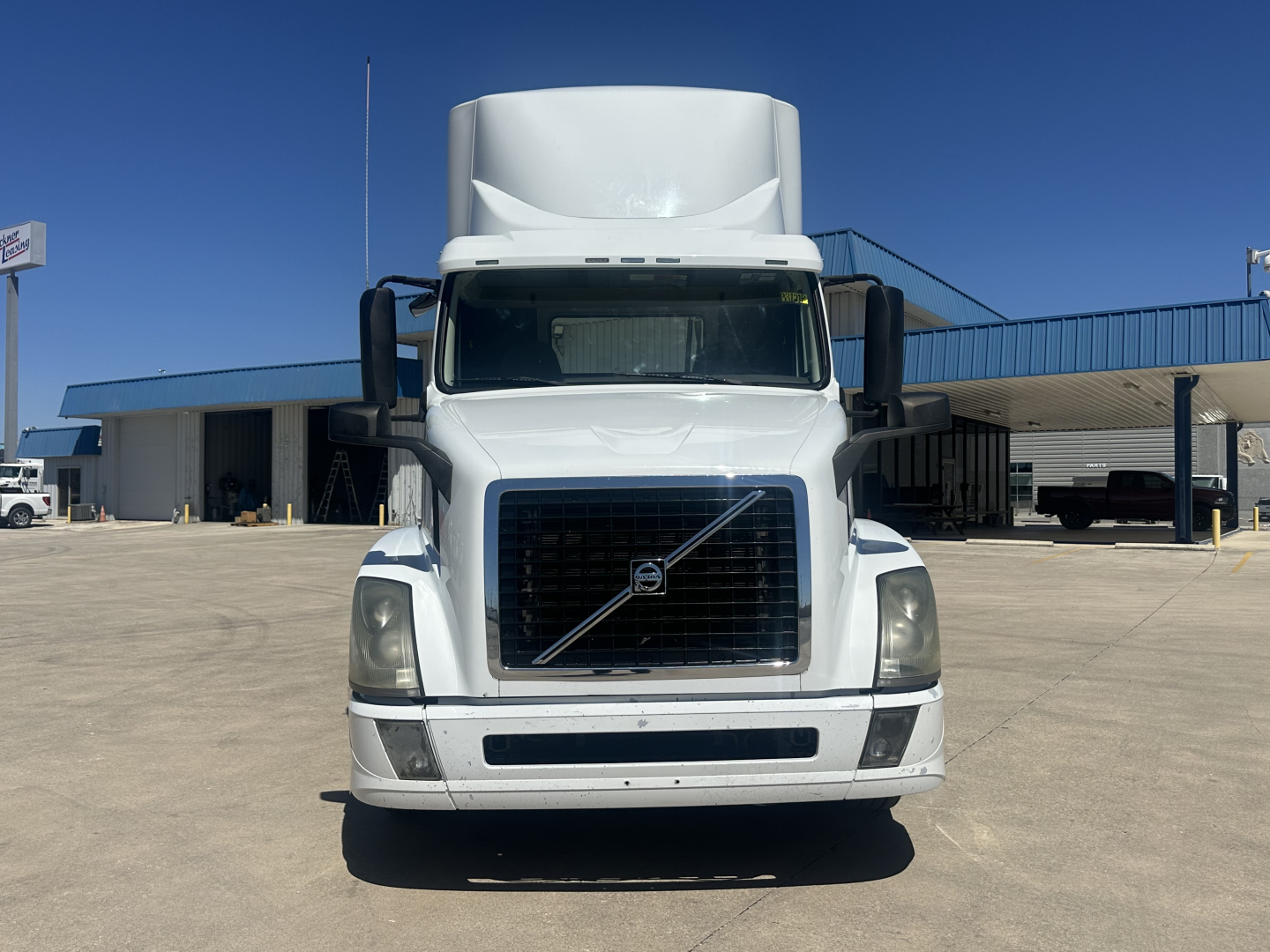 Volvo VNL64T300 truck front view showing grille and bumper in daylight.