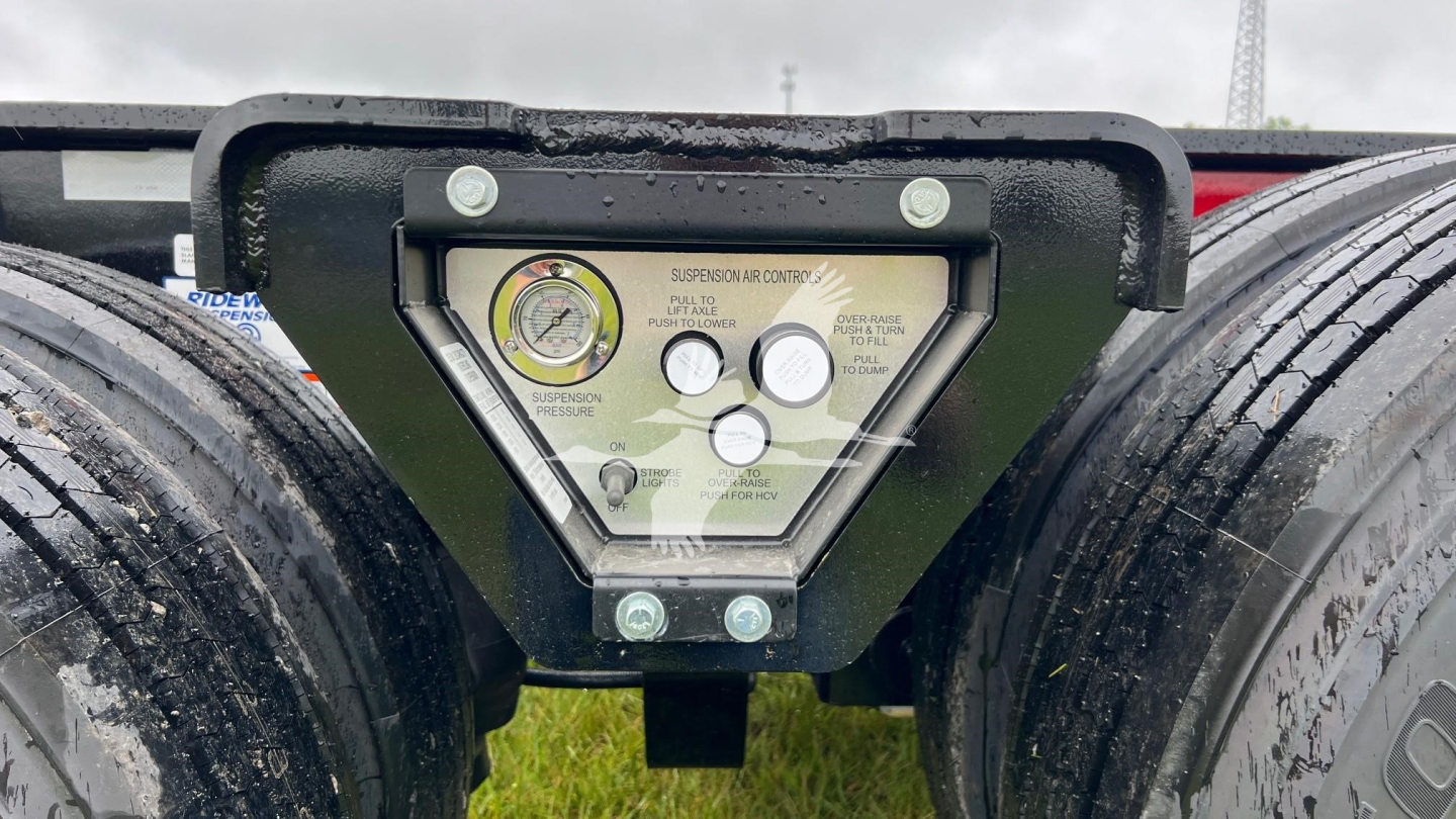 Trailer gauge panel showing air pressure and warning dials mounted on a lowboy trailer undercarriage.