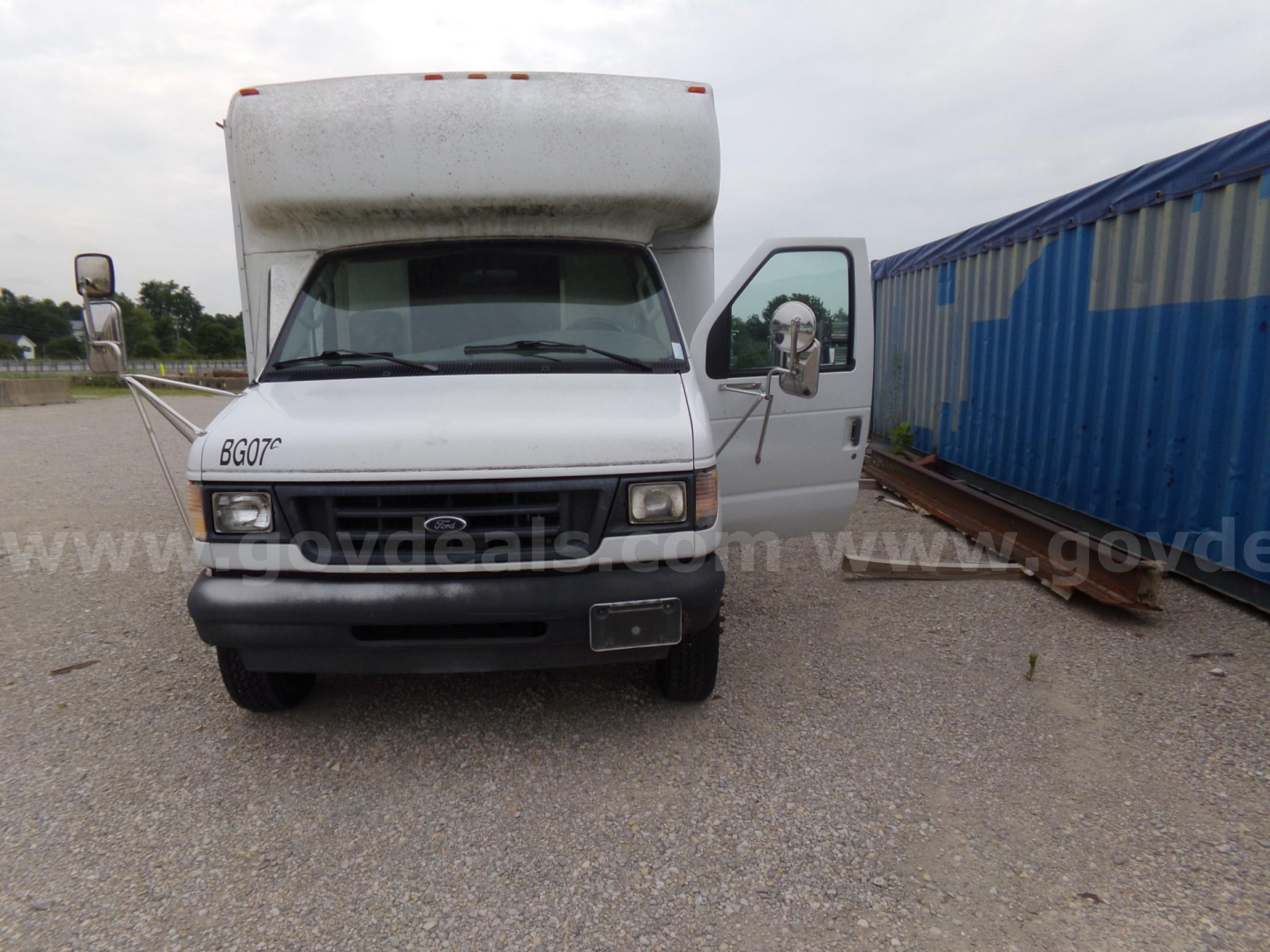 Ford E-450 box truck front view showing cab and cargo area with open passenger side door; grille and headlights visible; stock photo style.