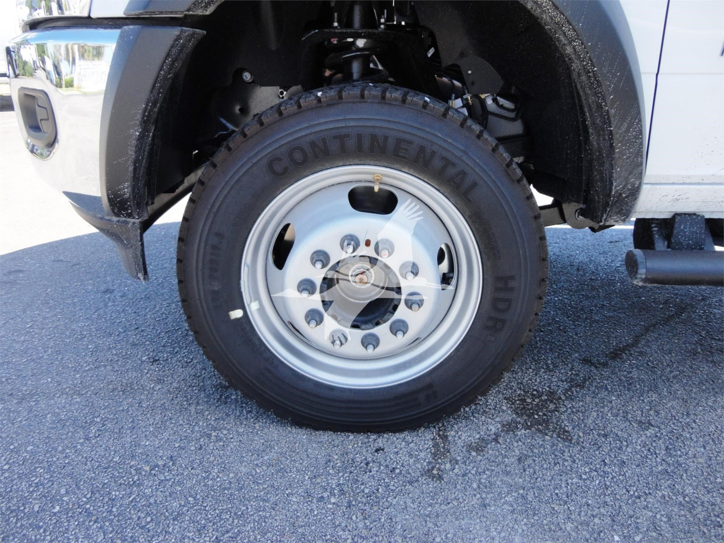 Truck front wheel and fender of a 2023 Ram 5500 HD hooklift truck showing Continental HD tire and wheel assembly.