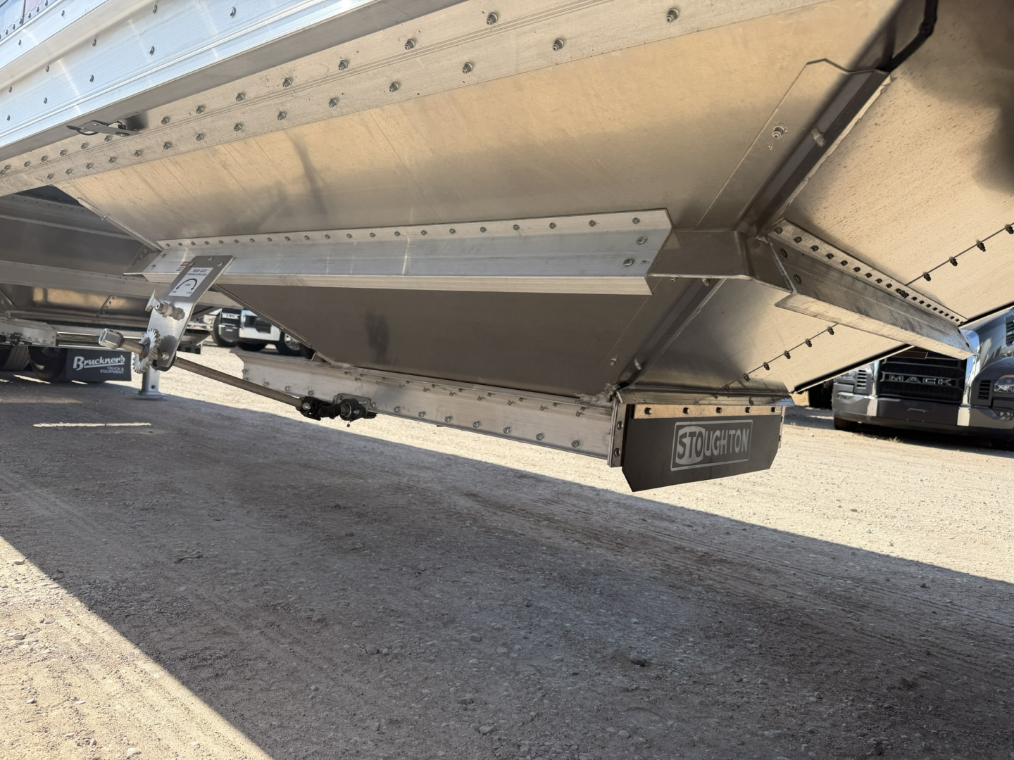 Trailer underside showing Stoughton hopper with corrugated 68" sidewalls, aluminum construction, andSupport/landing gear visible.