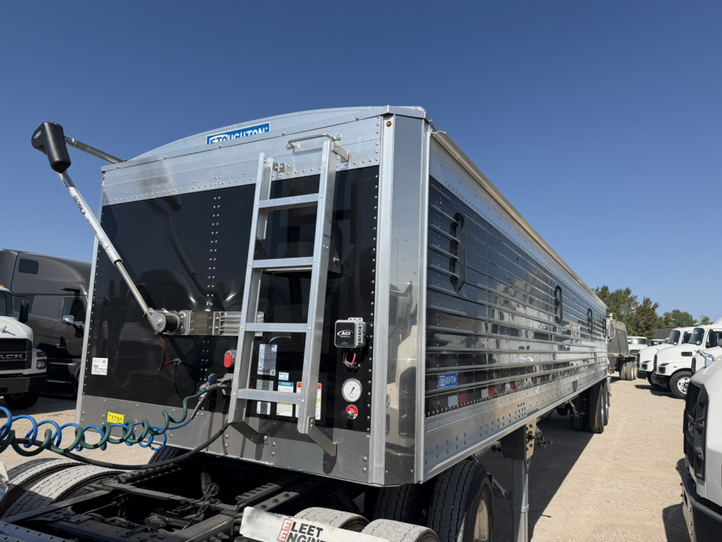 Stoughton 40' aluminum grain hopper trailer showing corrugated sidewalls, rear ladder, kingpin area, and dual wheels.