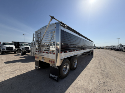 Aluminum grain hopper trailer with corrugated 68" sidewalls, 40' length, dual rear axles, rear tailgate, and reflective chrome finish.