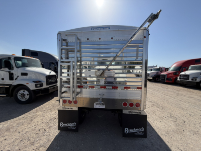 Stoughton 40' aluminum grain hopper trailer rear view with corrugated sidewalls and a rear ramp, chrome finish, multiple taillights, mud flaps, and VIN visible.