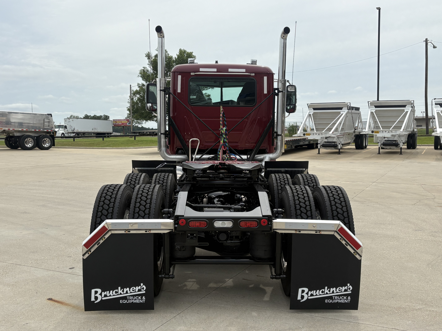 Rear view of a 2027 Mack PI64T truck tractor showing dual rear axles, fifth-wheel area, and mud flaps with Bruckner's Equipment branding.