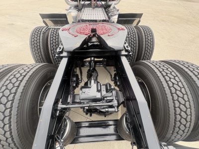 Mack PI64T chassis view showing drivetrain and dual rear axles with differential, undercarriage components and suspension in focus.