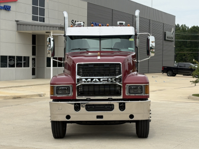 Mack PI64T conventional daycab truck front view. Large black grille with MAC K letters, maroon cab, chrome bumper, dual mirrors, headlights, and cab roof lights.