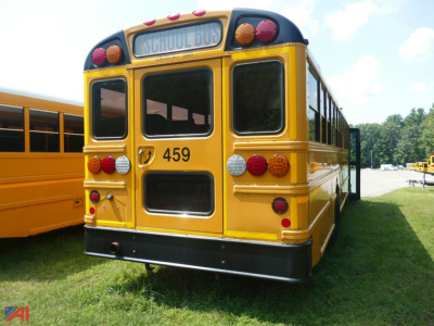 School bus rear view showing number 459 and a raised tail with lights, yellow body, back door, and large windows.