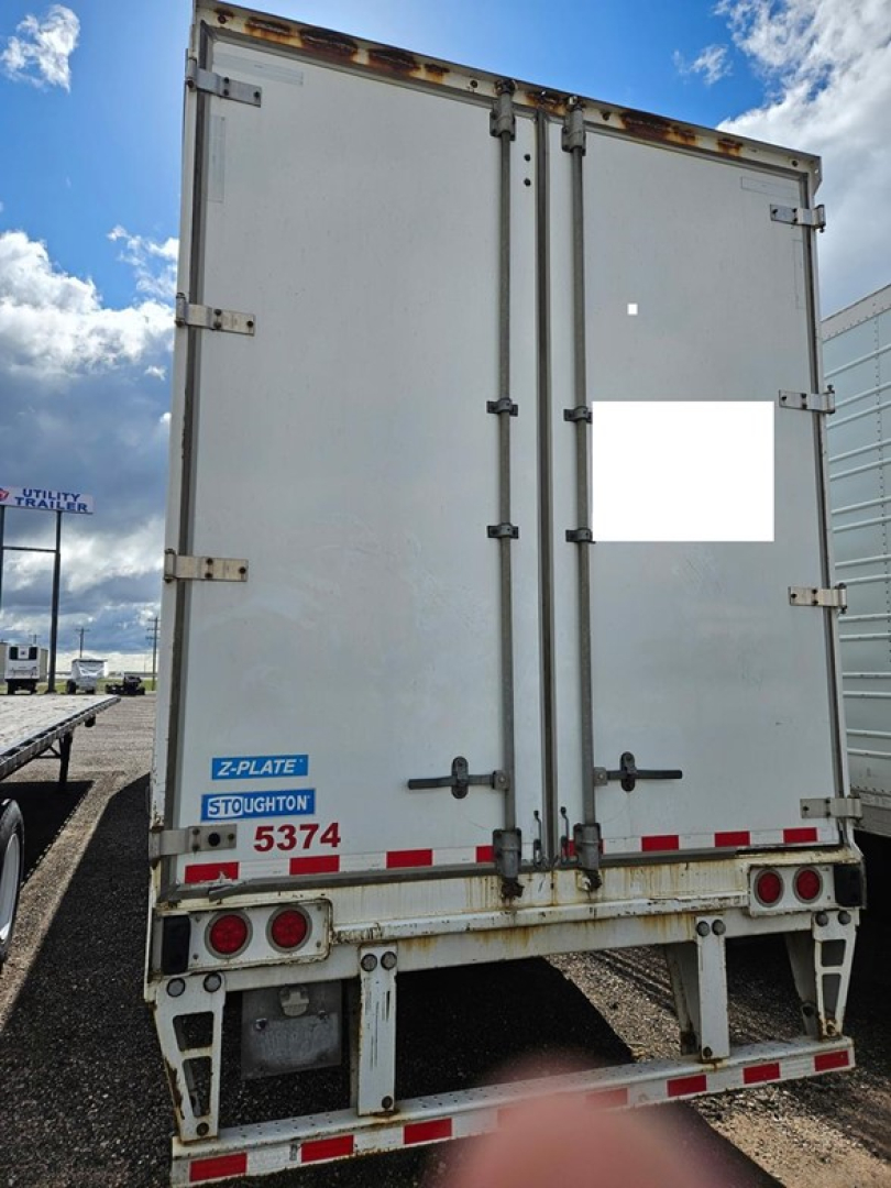 Rear view of a 2018 Stoughton air ride dry van trailer showing double rear doors, hinges, latches, and Stoughton plate with numbers.