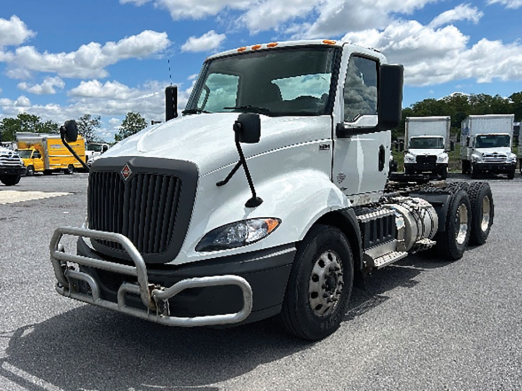 International RH613 cab and chassis showing front grille with bumper guard and dual rear axles.