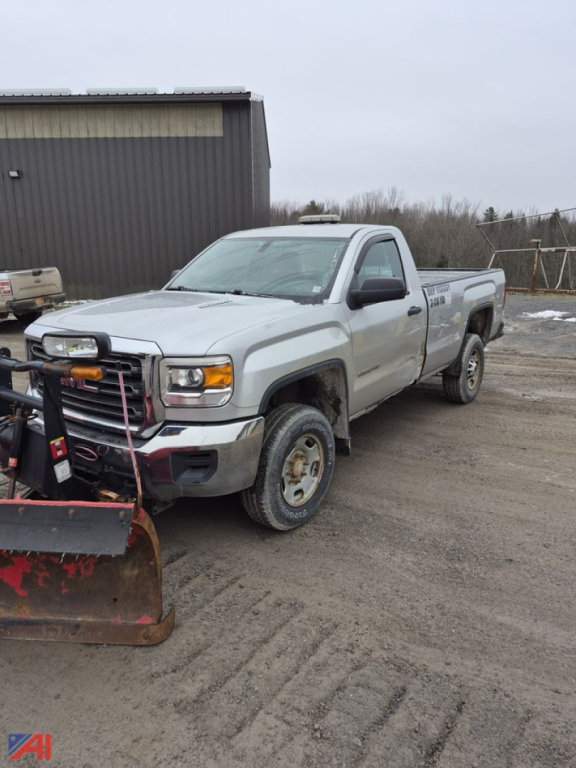 GMC Sierra 2500HD pickup truck with plow attached, light-gray/white body, 4x4, in a yard.