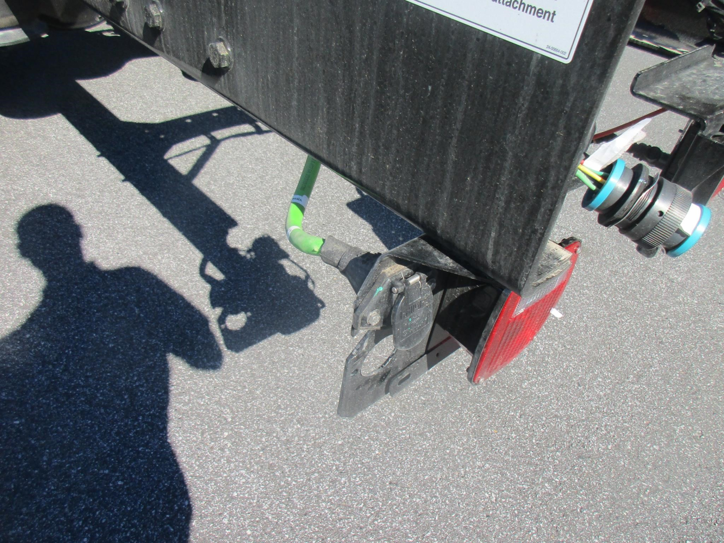 Freightliner truck chassis rear showing hitch, taillight, and wiring harness with label visible.