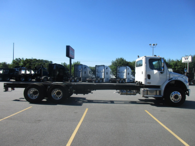 Truck chassis with cab in white, Freightliner Business Class M2 106 Plus, long wheelbase chassis in a parking lot.