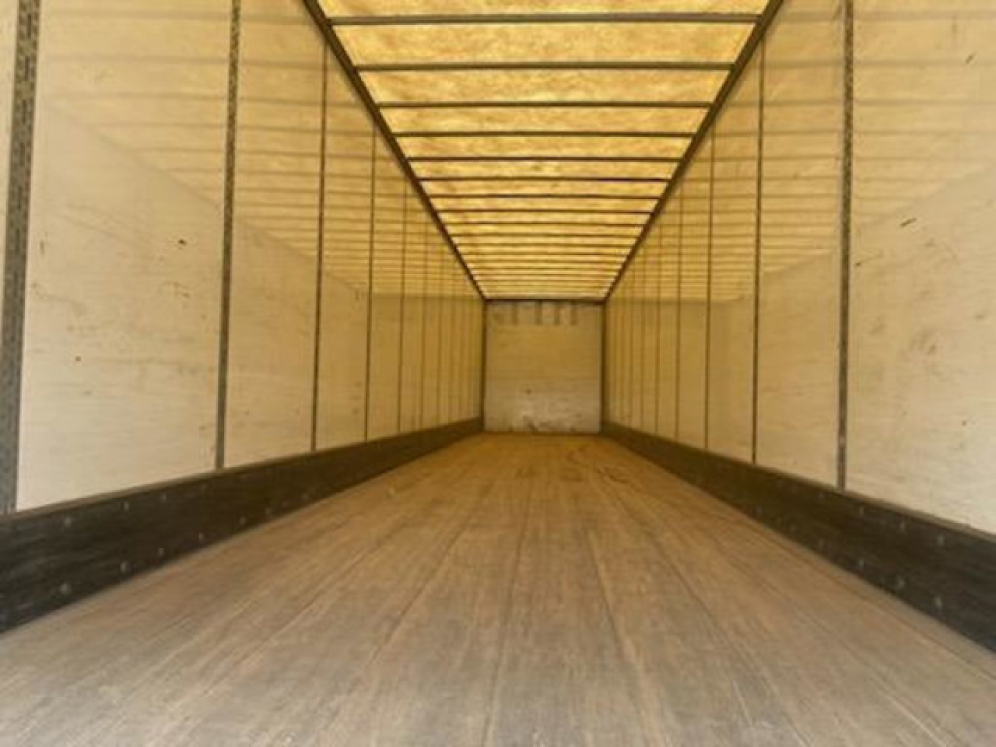 Trailer cargo space interior view of a 2016 Wabash van showing empty box with wooden floor, side walls, and ceiling ribs.