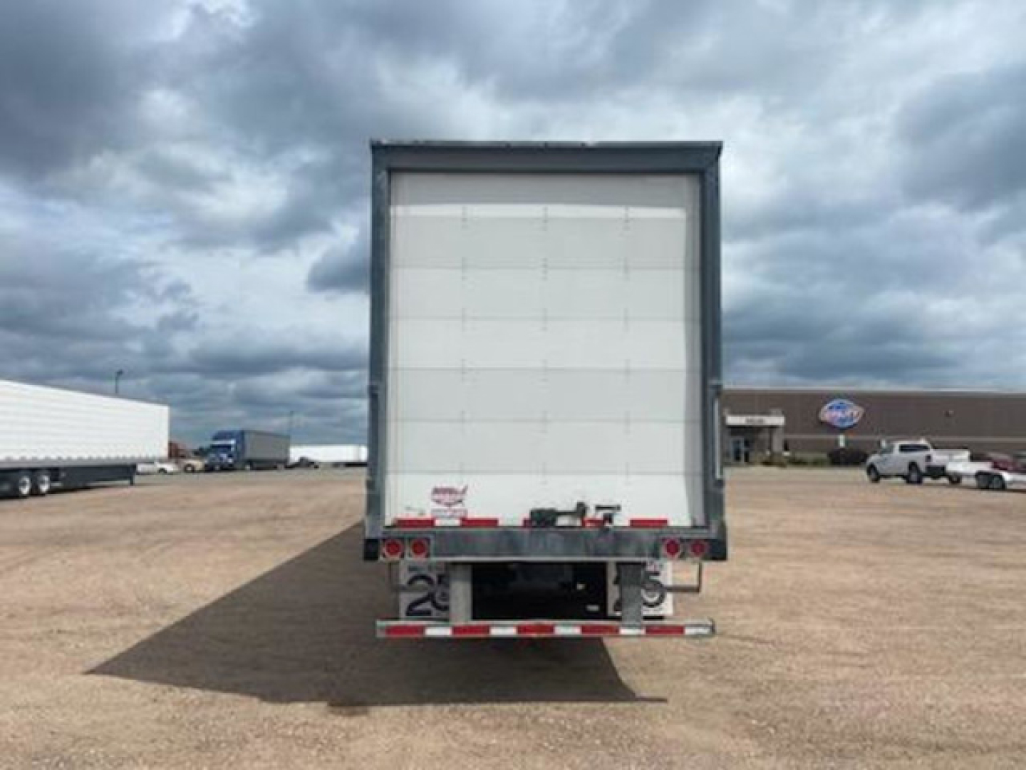 Back of a 2016 Wabash van trailer showing rear doors, bumper with lights, and bumper guard.