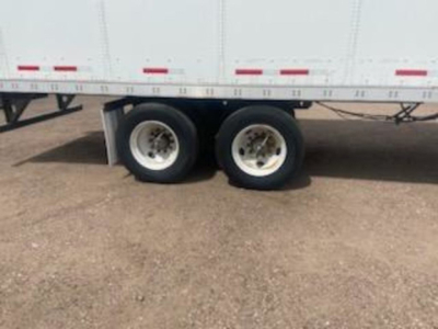 Trailer wheel duo of a white 2016 Wabash van showing dual rear axles and tire rims.