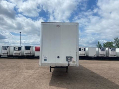 Rear view of a white 2016 Wabash van trailer on a lot with other trailers in background, with registration and stickers near the bottom edge.