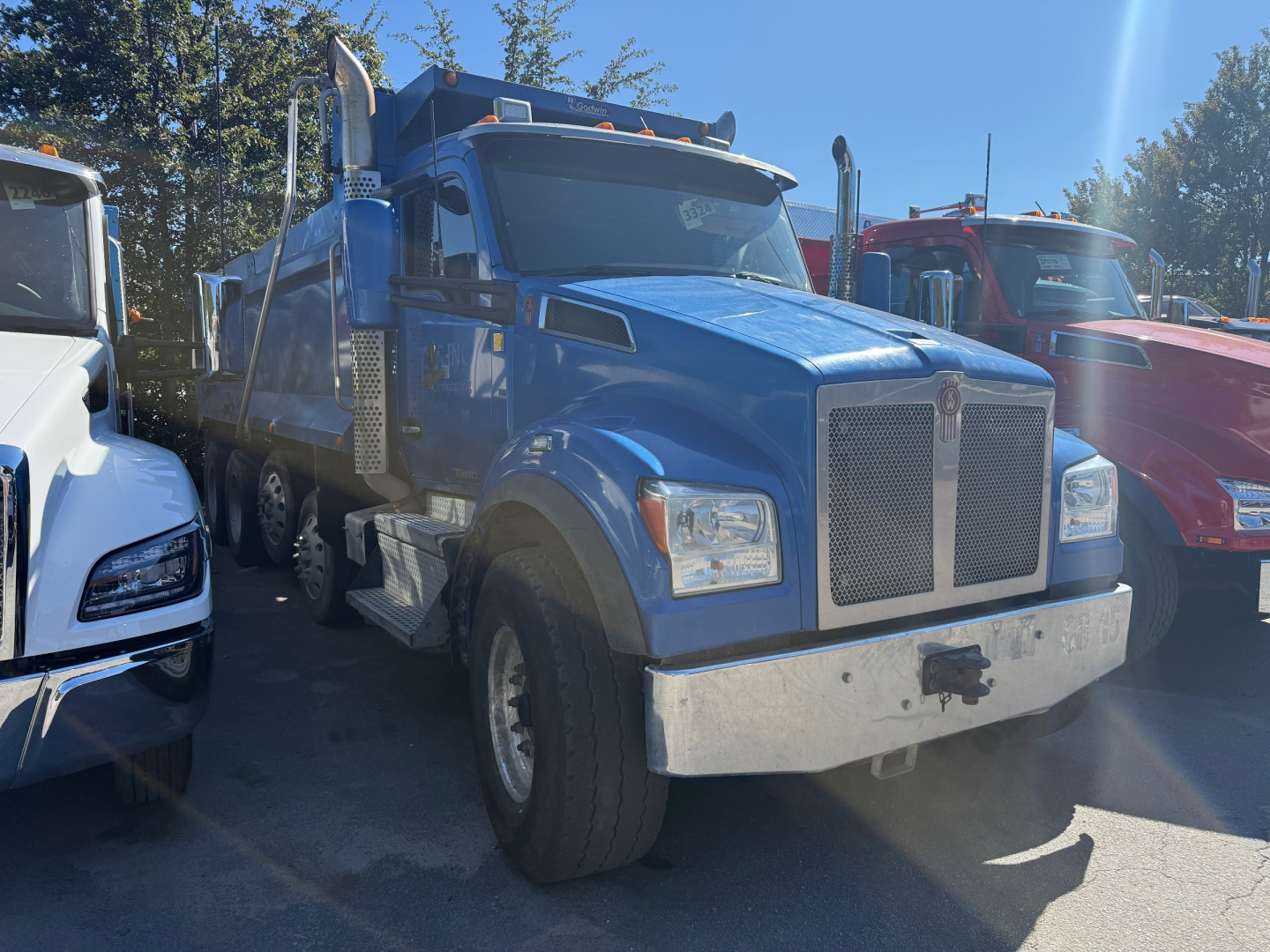 Blue 2019 Kenworth T880S dump truck front-left view with chrome grille, large bumper, and dual rear wheels visible.