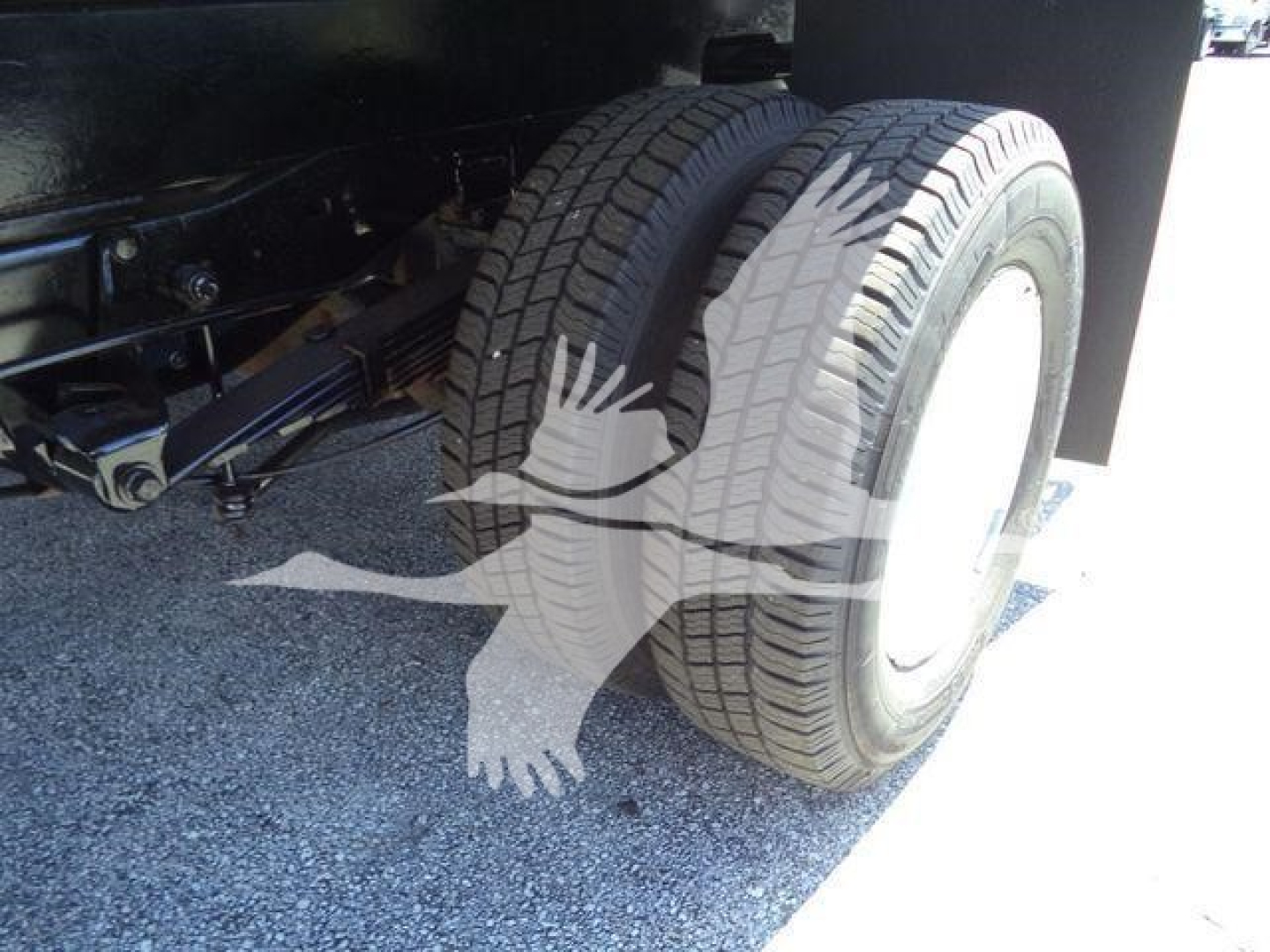 Semi truck rear dual tires and suspension undercarriage view on a Ford E450 dump truck.