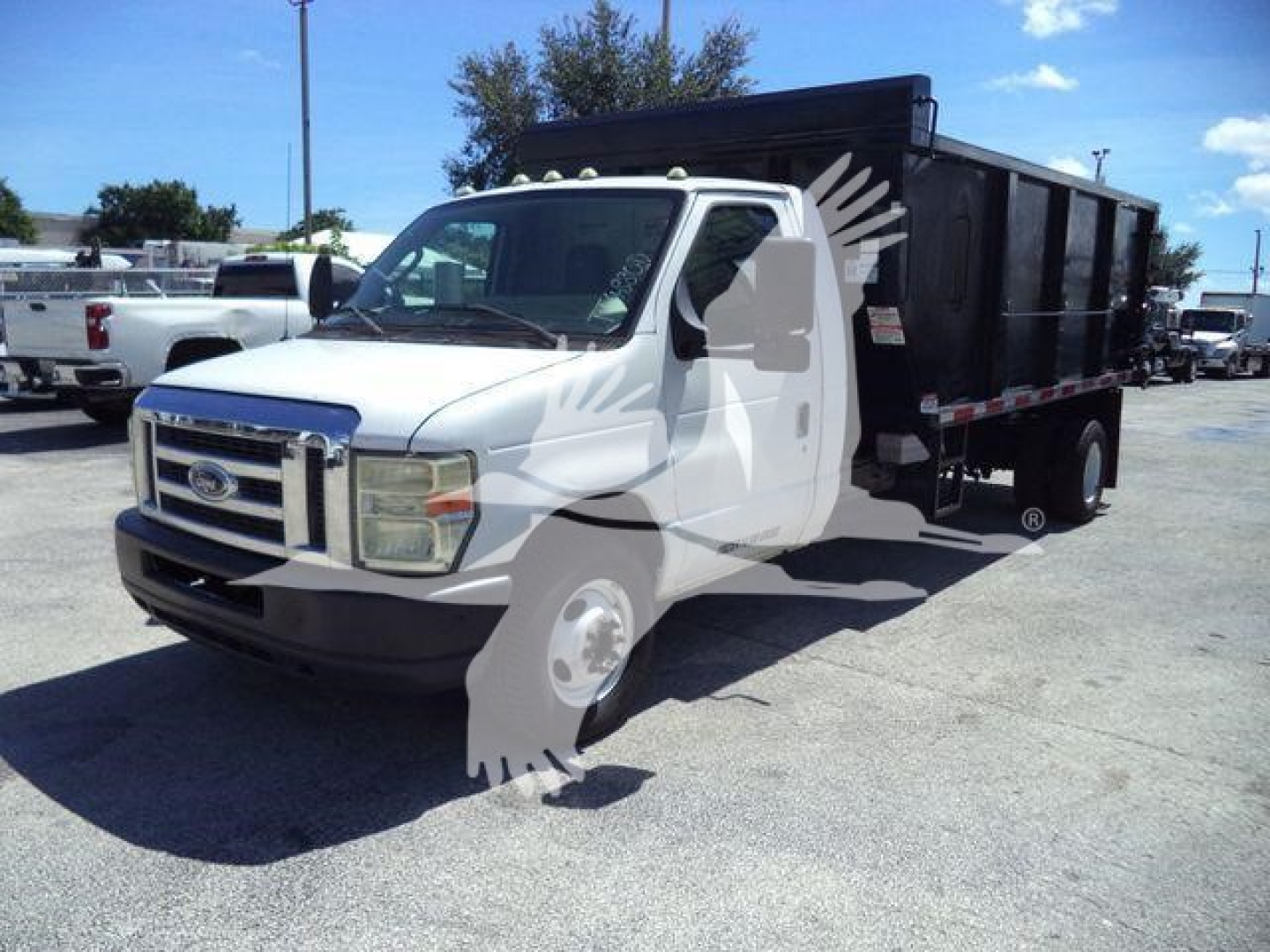 Dump truck, white cab with black dump bed, Ford emblem on grille, side view mirror, daylight; stock number T96628FM; used vehicle.