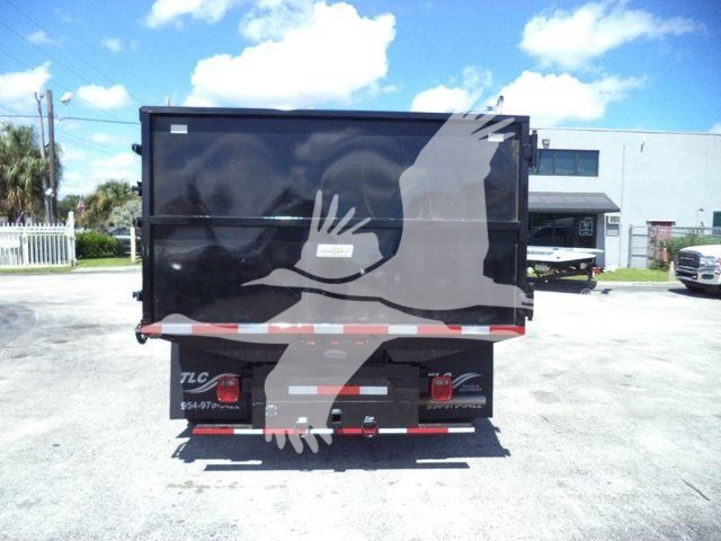 Dump truck bed rear view showing graphic design on tailgate and taillights.