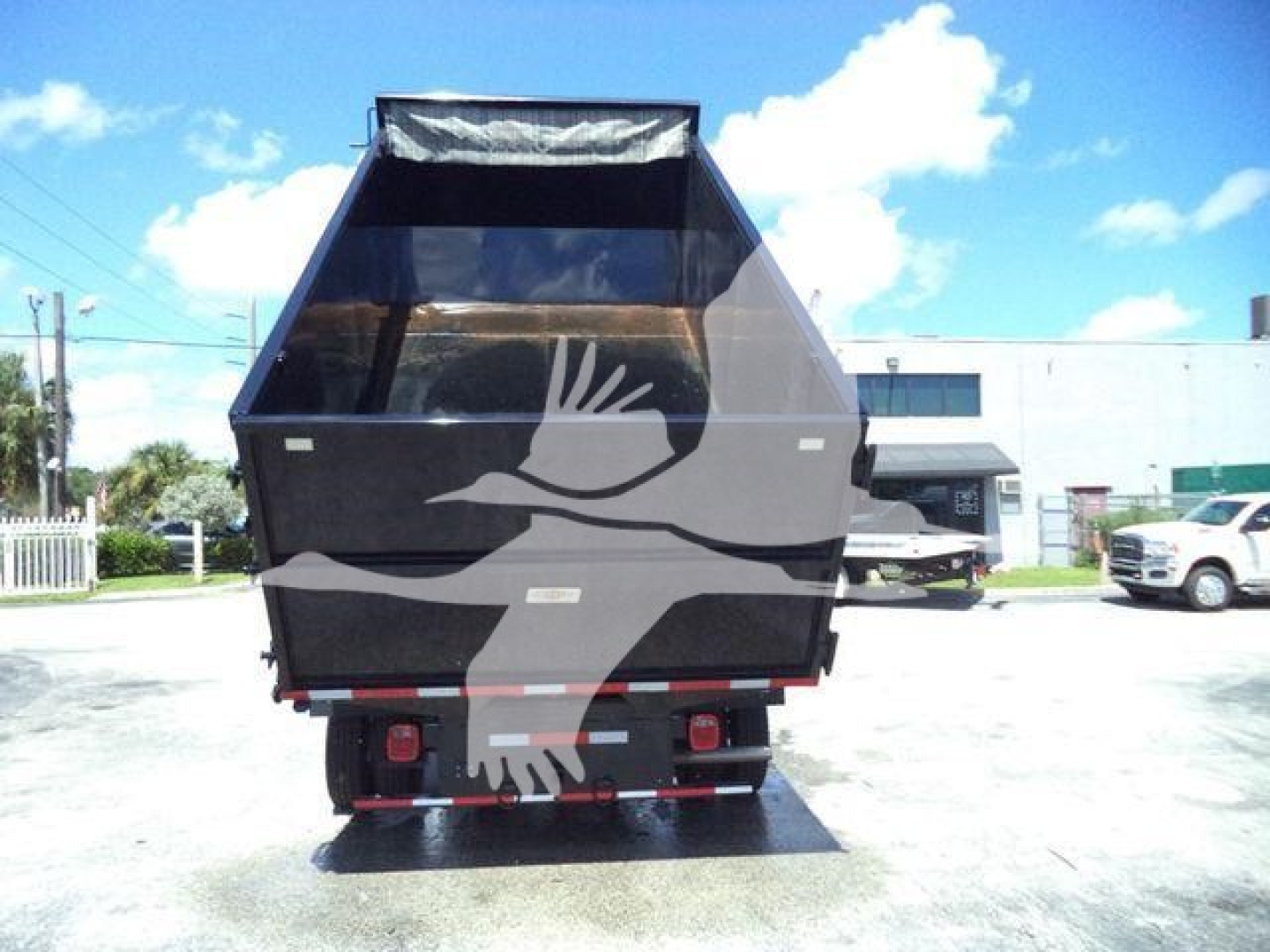 Ford E-450 dump truck rear view showing cargo bed and tow hitch area.