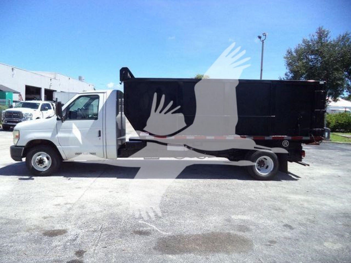 Ford E450 dump truck side view showing black dump body and white cab.