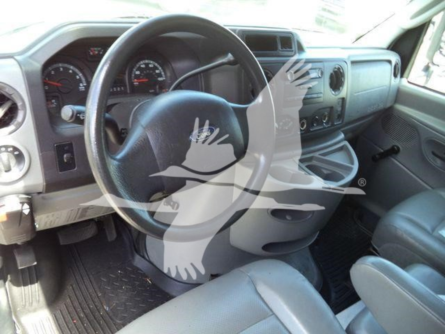 Interior View of a Ford E-450 Cab showing steering wheel, dashboard, and driver's seat with basic gauges and controls.
