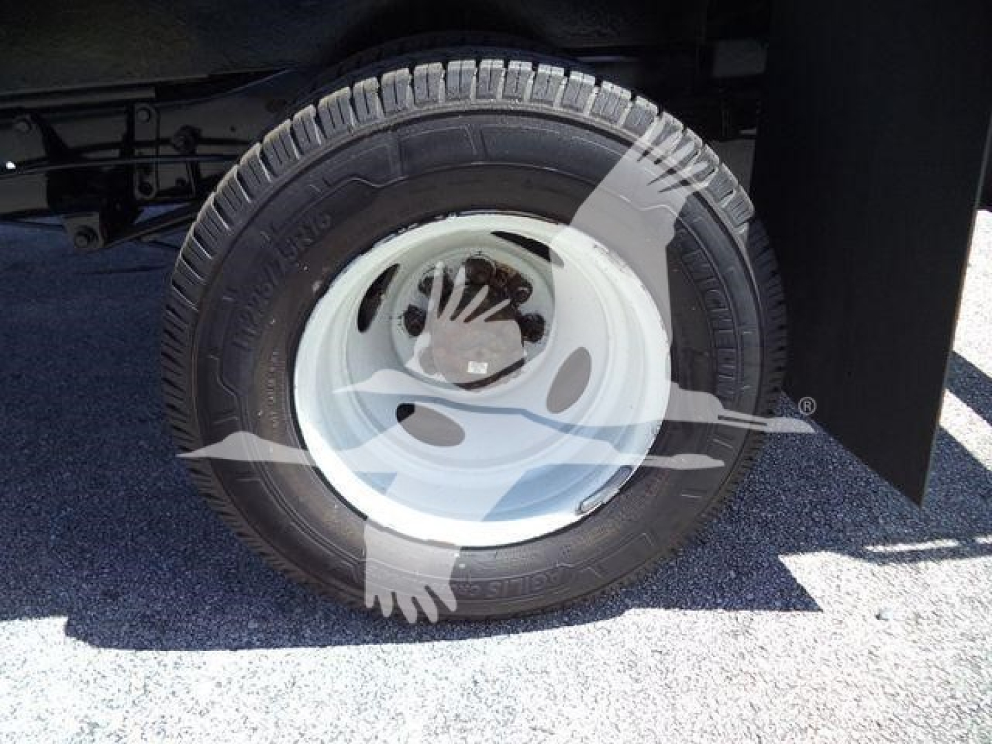 Ford E450 wheel and tire on a dumping truck view showing steel wheel and tire tread.