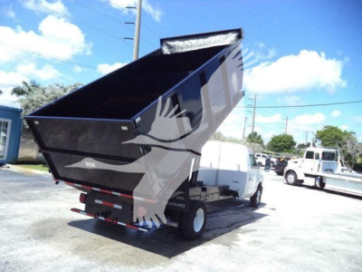2011 Ford E450 dump truck with raised dumping bed, rear view showing dump mechanism and chassis.