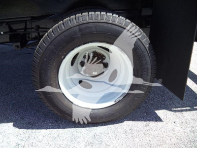 Ford E450 wheel and tire on a dumping truck view showing steel wheel and tire tread.