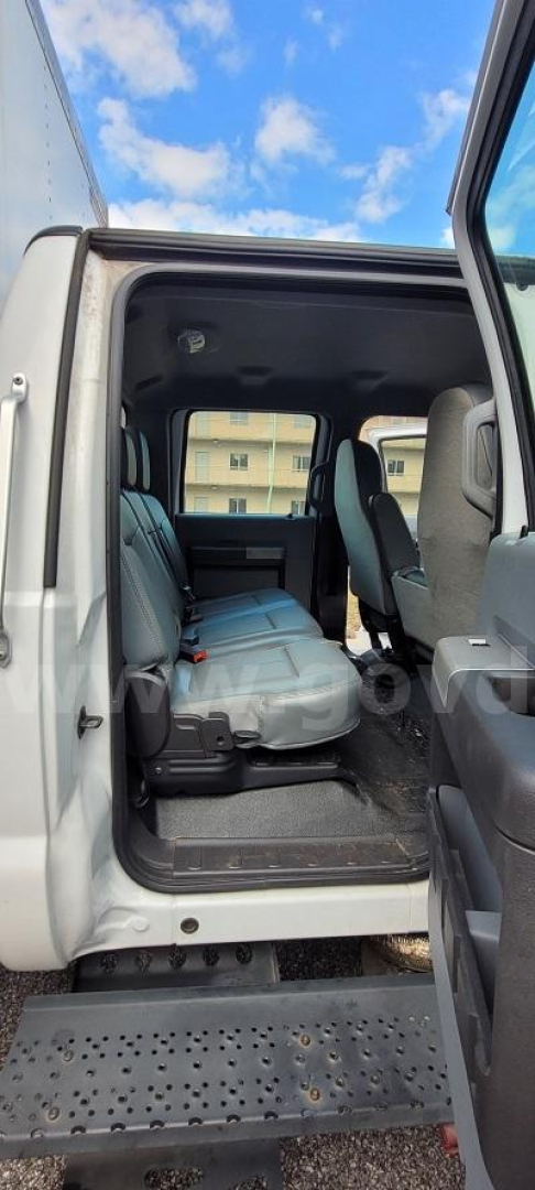 Ford F-650 in-service interior showing front and rear seating, side step, and open cab with gray seats.