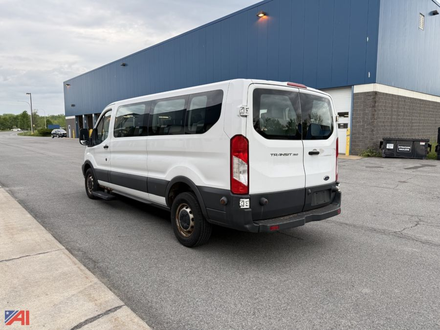 Ford Transit cargo passenger van in white rear three-quarter view showing Transit badge and rear doors.
