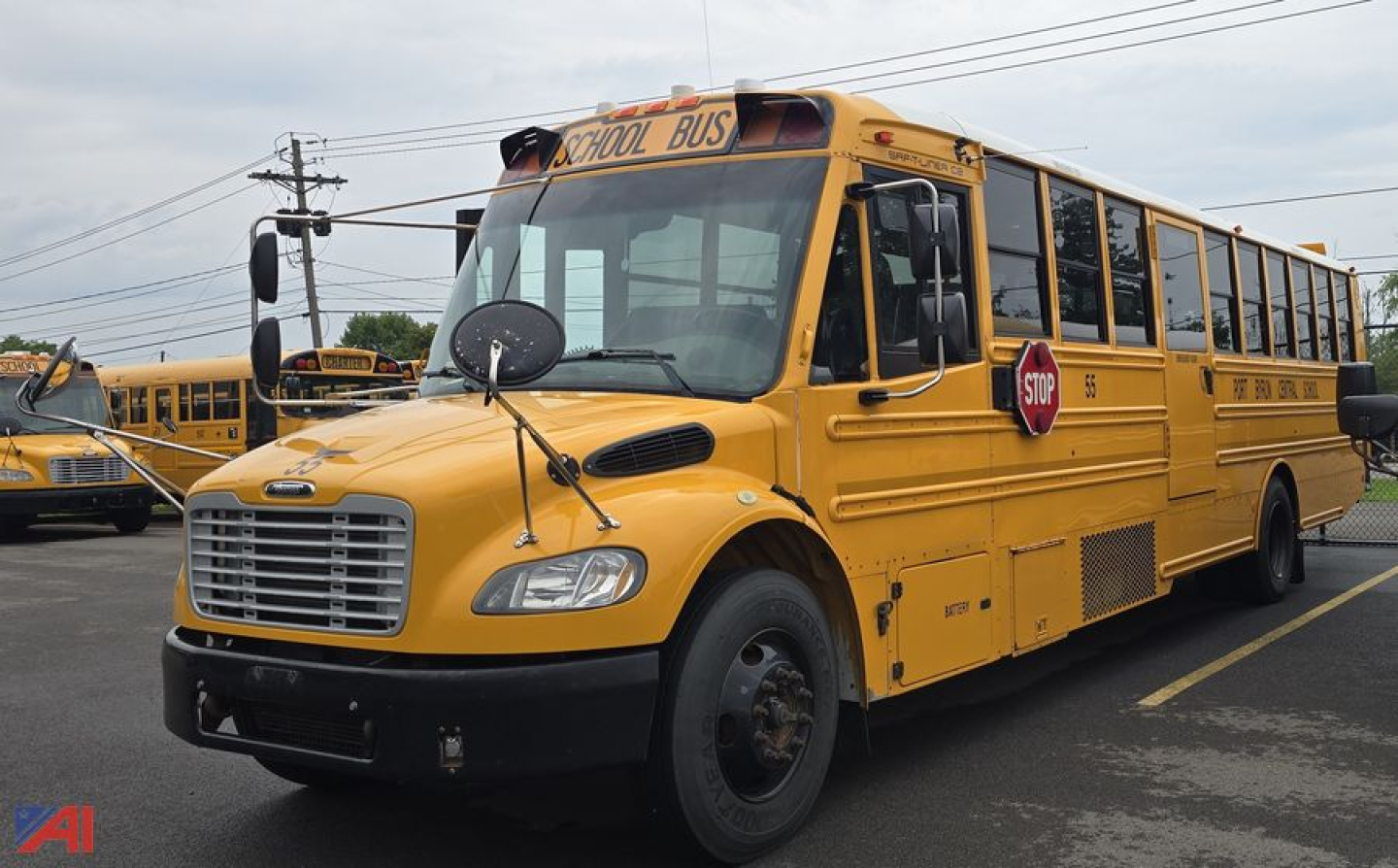 School bus in yellow showing front grille and stop sign, with 'SCHOOL BUS' sign on roof and passenger windows along the side.