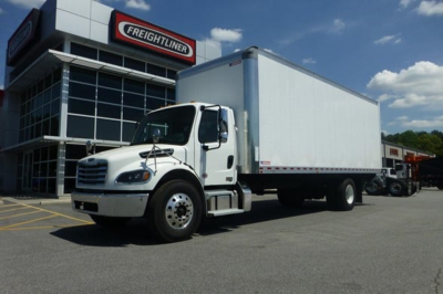  Freightliner M2 106 Plus box truck in dealership lot showing white cab and large rectangular cargo box.