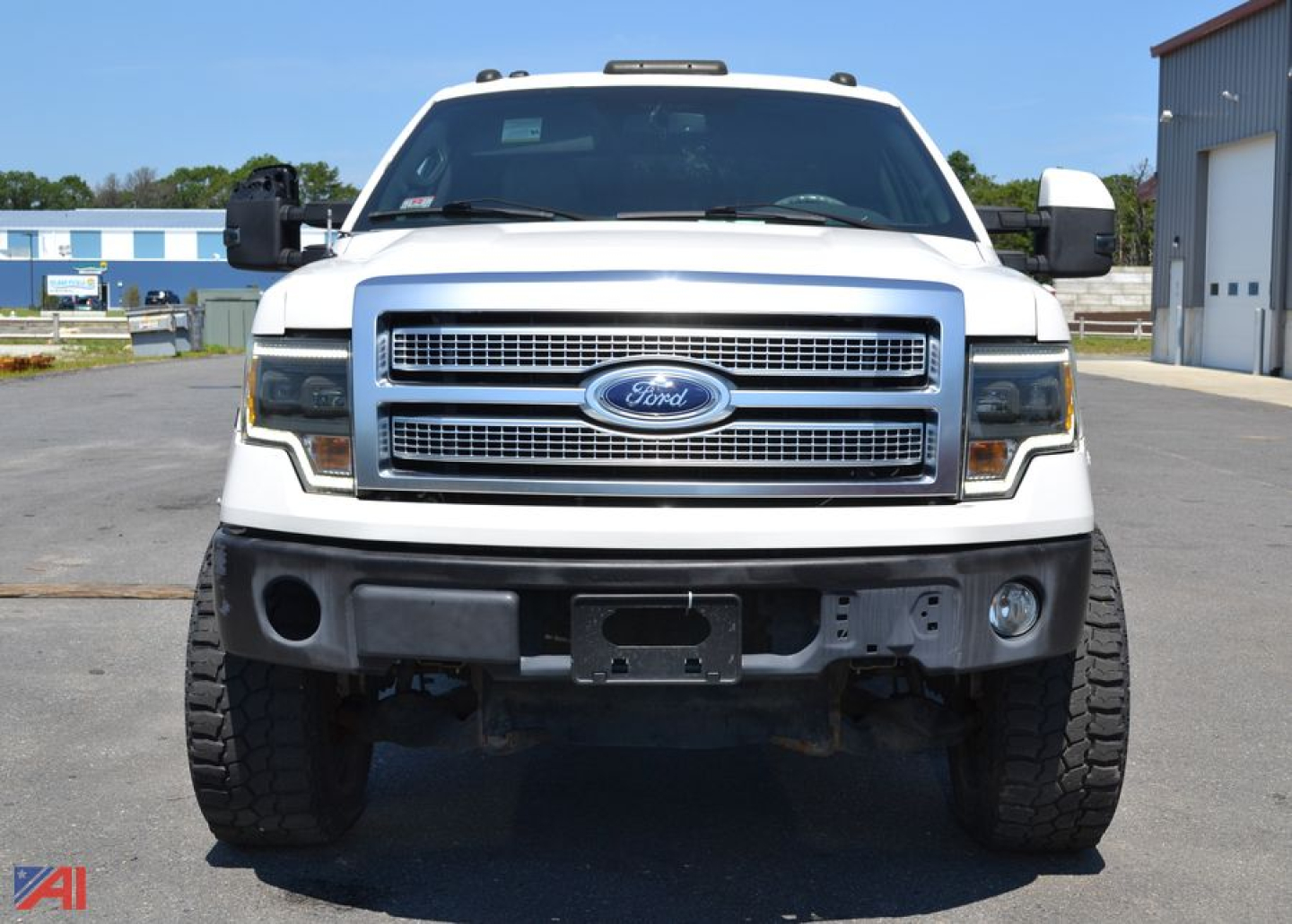 Front view of a white 2011 Ford F-150 Crew Cab pickup truck showing grille, headlights, and bumper.