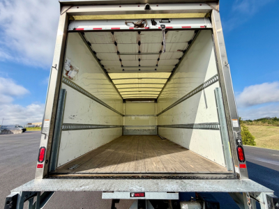 Freightliner M2-106 box truck cargo area with empty interior and wooden floor, open rear doors.