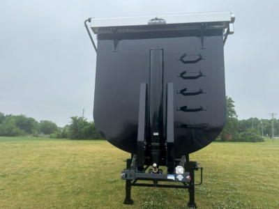 Dump trailer in side view showing front vertical hitch and storage ties, Armor Lite 40' x 100" scrap trailer with black hopper and ladder hooks visible.