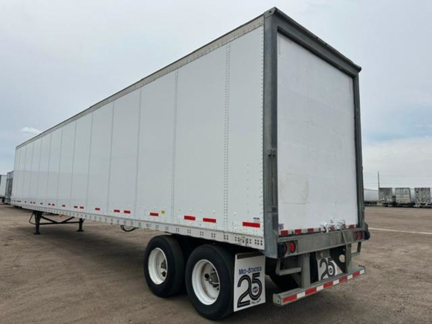 Trailer side view of a 2014 Wabash van trailer, silver/gray exterior, dual rear wheels, rear doors, stock number U90818, VIN 1JJV532D3EL812530.