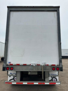 Rear view of a Wabash van trailer showing rear bumper, taillights, and license plate areas with stock number U90818 and US flag decals.