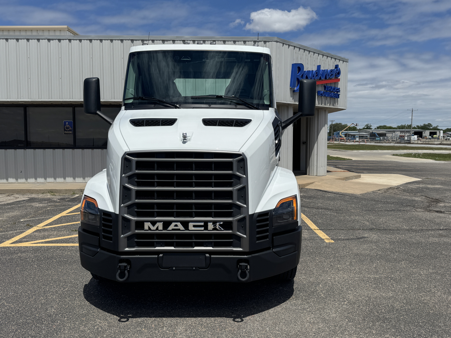 Front view of a white 2027 Mack AN64T conventional daycab truck showing bold grille and MACk lettering on the bumper.