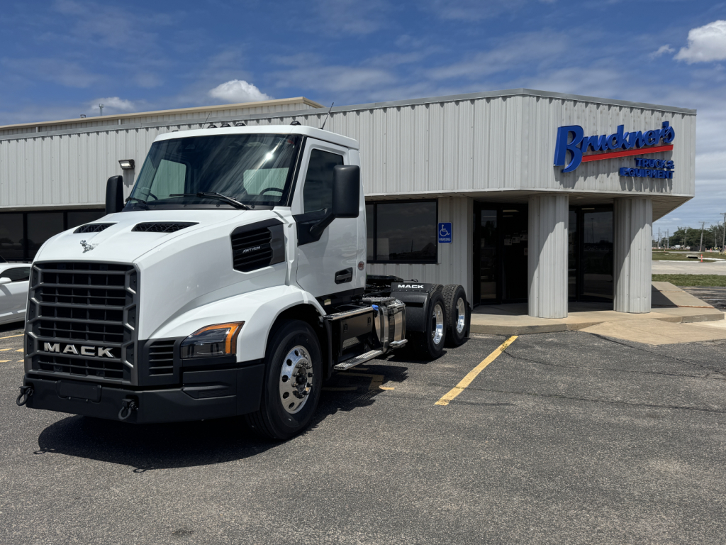 Mack AN64T truck in front of dealership building with 6x4 axle configuration and white cab.