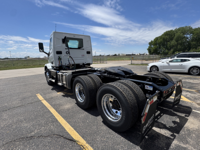 Truck chassis and rear sleeper cab view showing dual rear axles and fifth wheel mount on a white 2027 Mack AN64T conventional daycab.