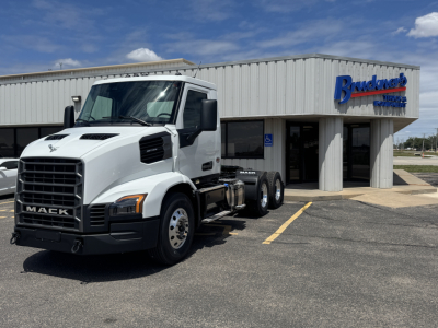 Mack AN64T truck in front of dealership building with 6x4 axle configuration and white cab.