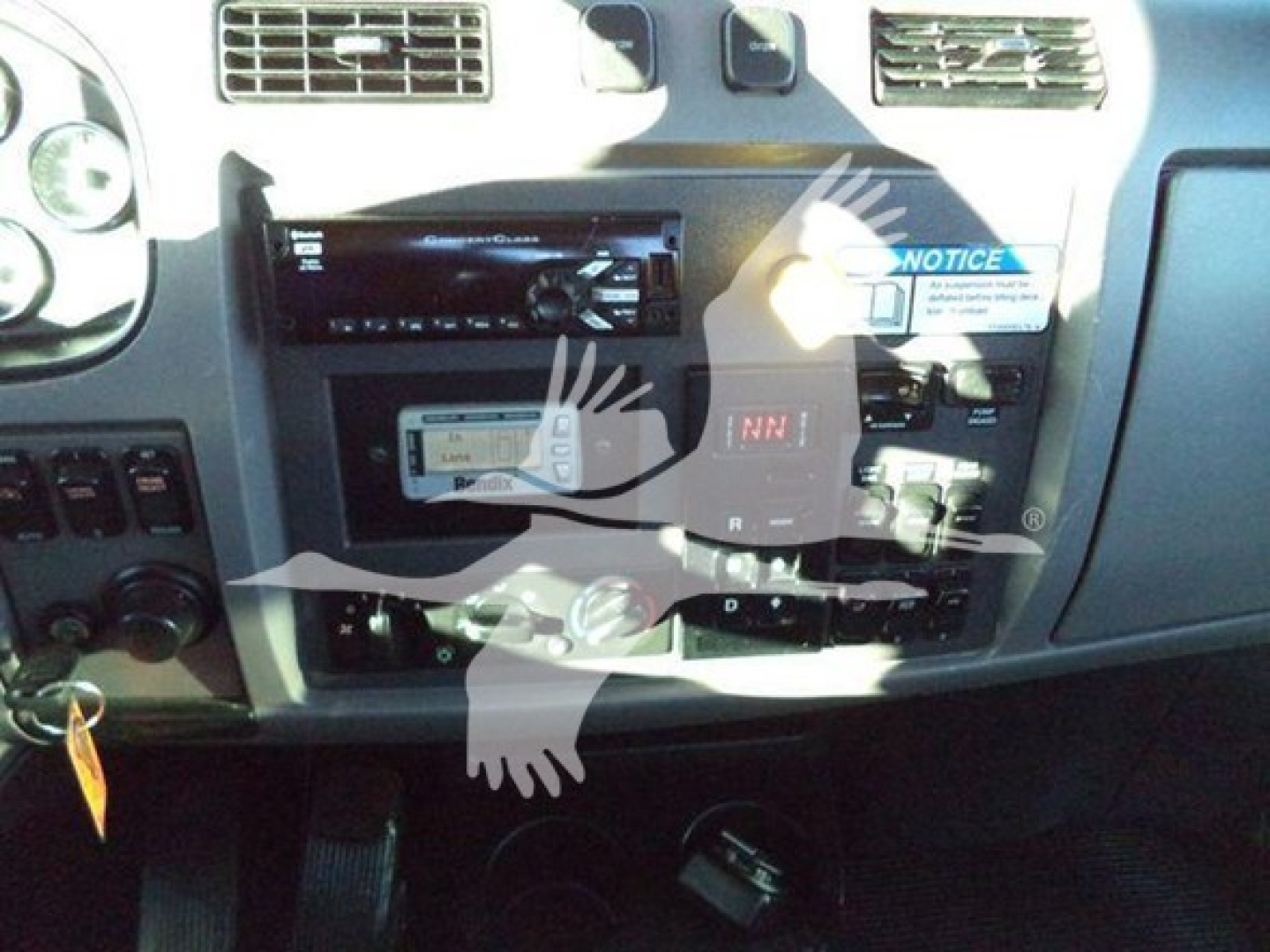 Dashboard area of a 2020 Peterbilt 337 showing radio/stereo head unit, control panels, gear selector, and dashboard stickers.